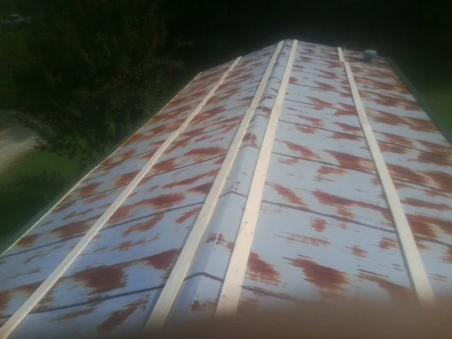 Rusted metal roof panels with new wood purlins before replacement — Storm Damage Roof Repair in Helena by Roofing Brothers